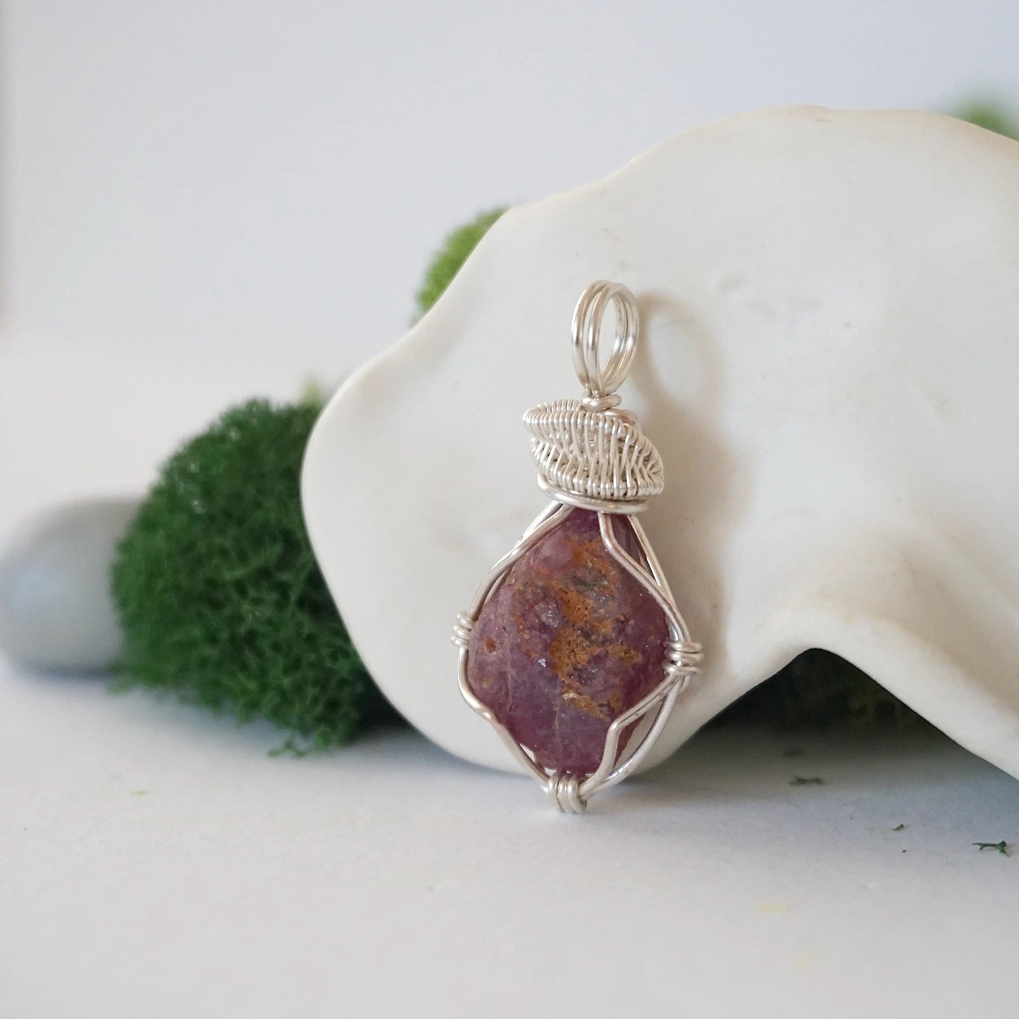 Left side view of raw ruby pendant highlighting silver wire wrap craftsmanship — natural crystal pendant, nickel-free copper wire