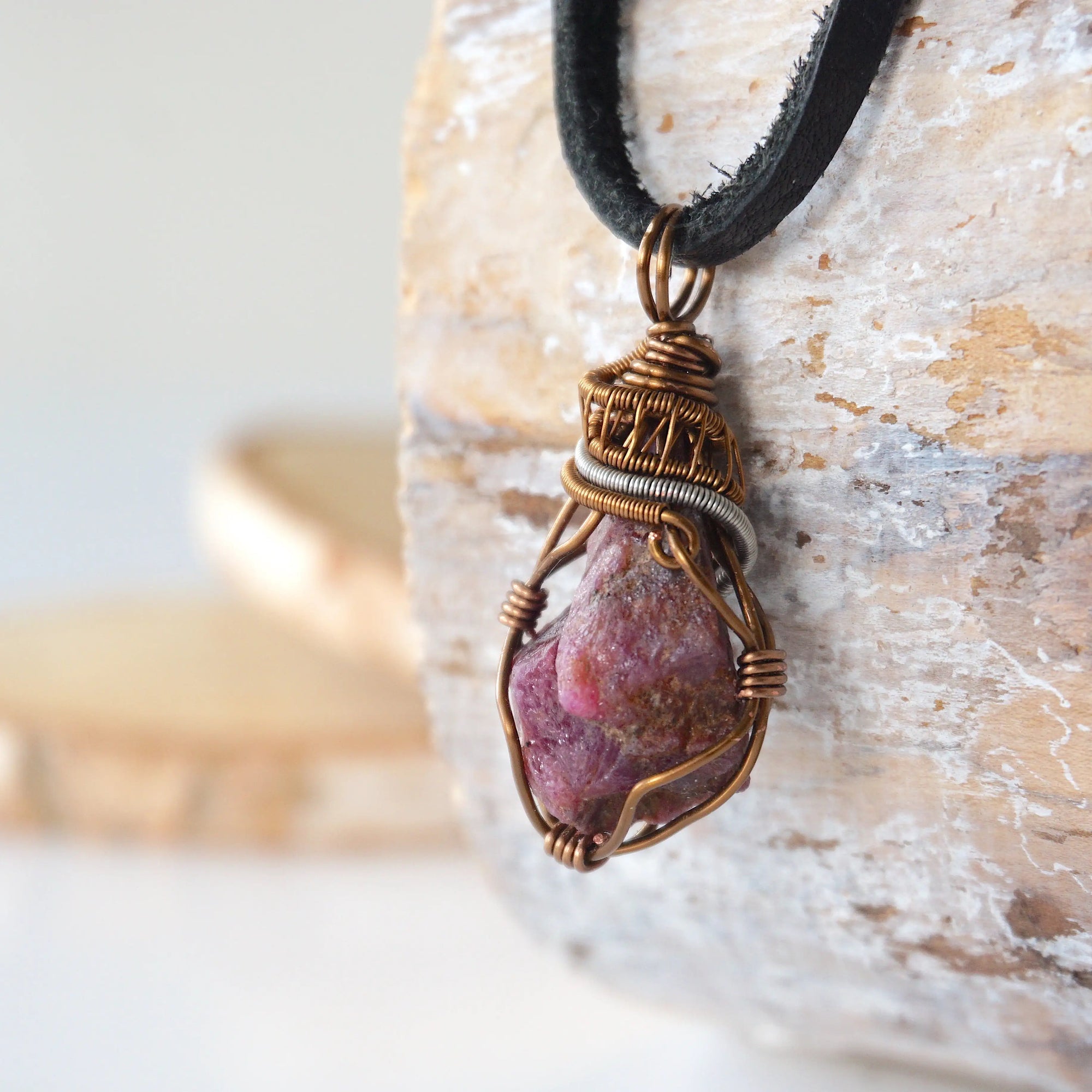 Left side view of raw ruby pendant highlighting bold two-tone wire wrap craftsmanship — men's natural crystal pendant, nickel-free copper wire