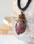 Left side view of raw ruby pendant highlighting bold two-tone wire wrap craftsmanship — men's natural crystal pendant, nickel-free copper wire