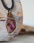 Right side view of men's handcrafted raw ruby pendant showing two-tone bronze and dark silver artisan wire wrapping detail