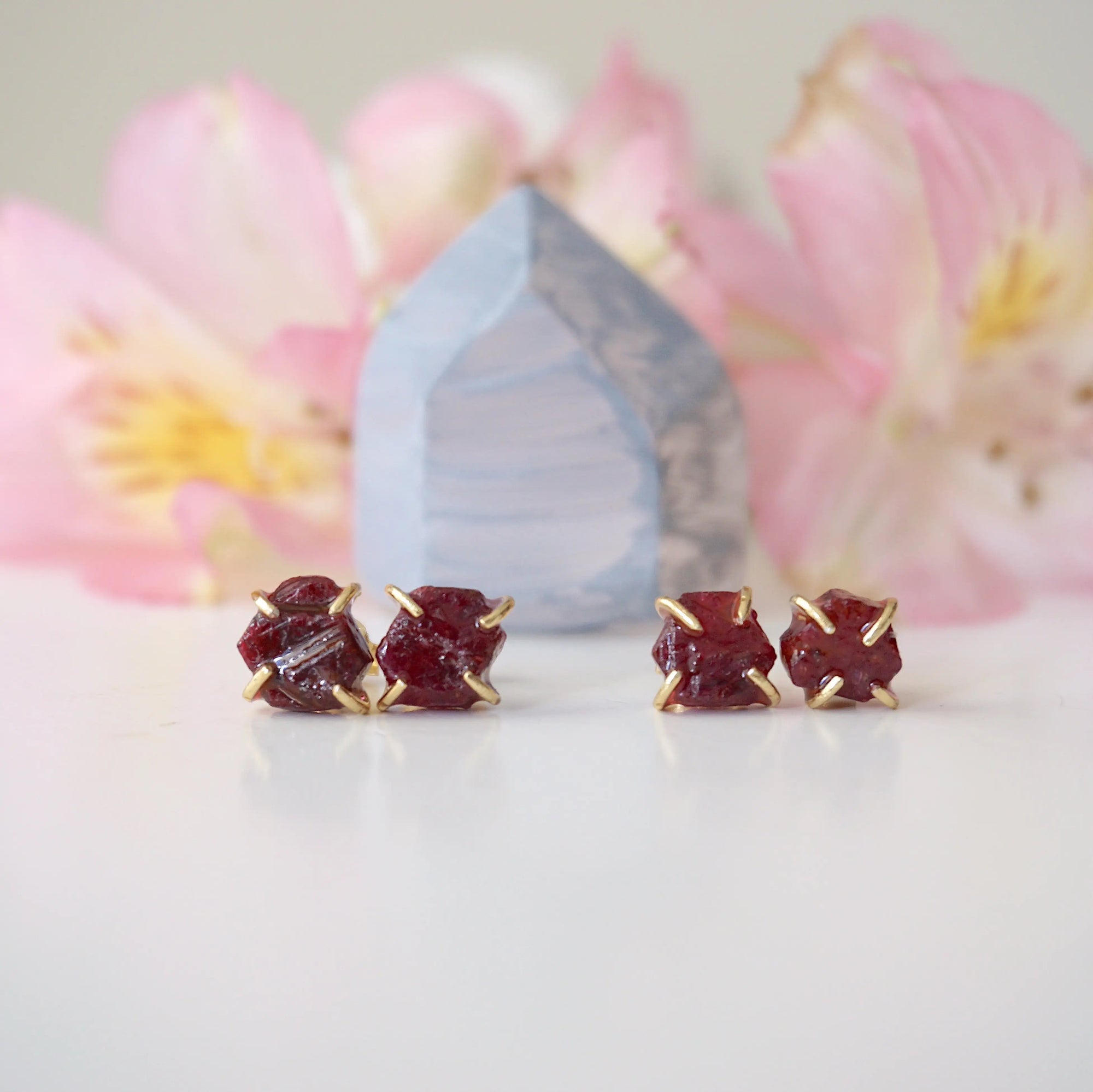 Two pairs of raw ruby prong stud earrings showing natural variation in stone shape, size, and colour — select your own pair, one of a kind by nature