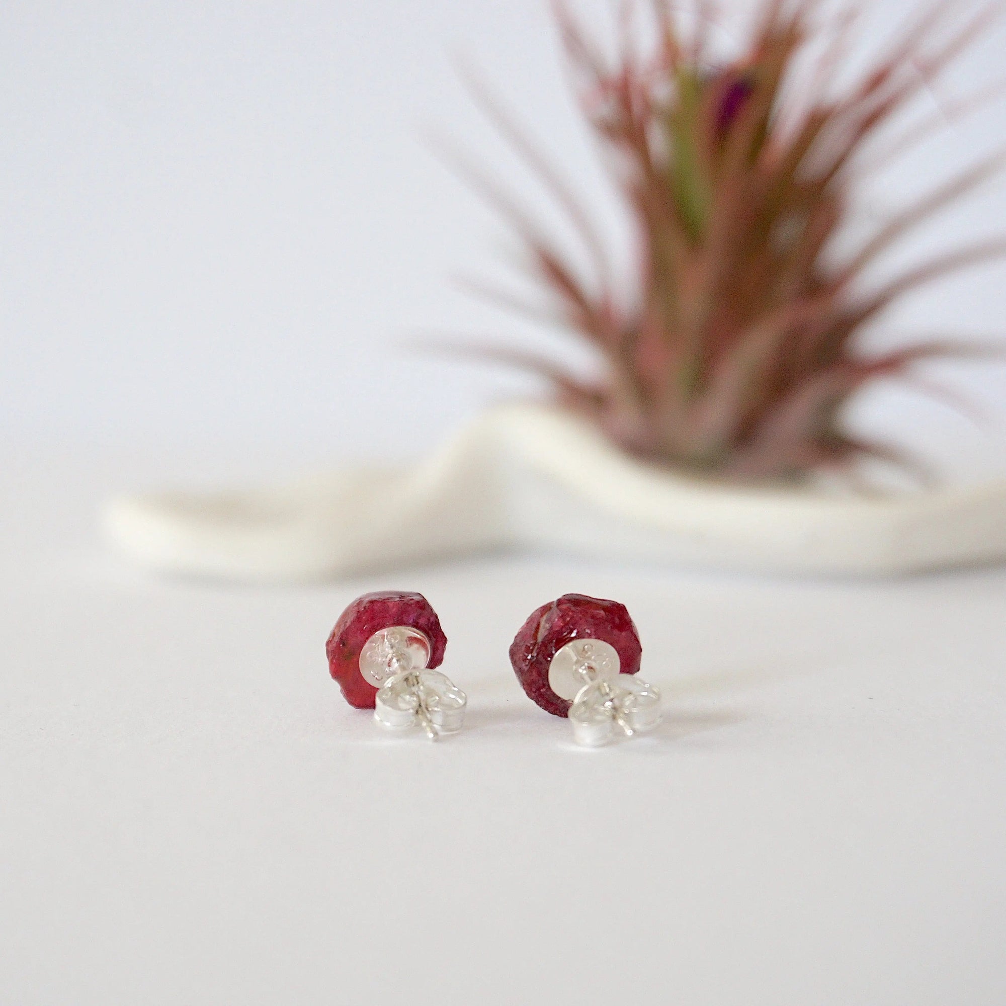 Back view of raw ruby stud earrings showing 925 sterling silver posts and butterfly backs — natural crystal earrings detail