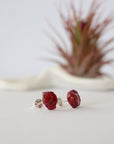 Side view of raw ruby stud earrings showing natural rough stone texture and sterling silver post — handmade gemstone earrings