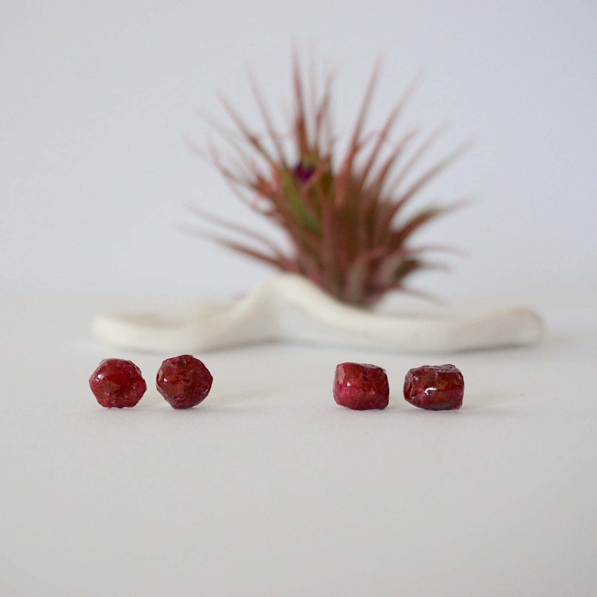 Two pairs of raw ruby stud earrings showing natural variation in stone shape, size, and colour — select your own pair, one of a kind by nature
