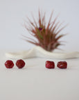 Two pairs of raw ruby stud earrings showing natural variation in stone shape, size, and colour — select your own pair, one of a kind by nature