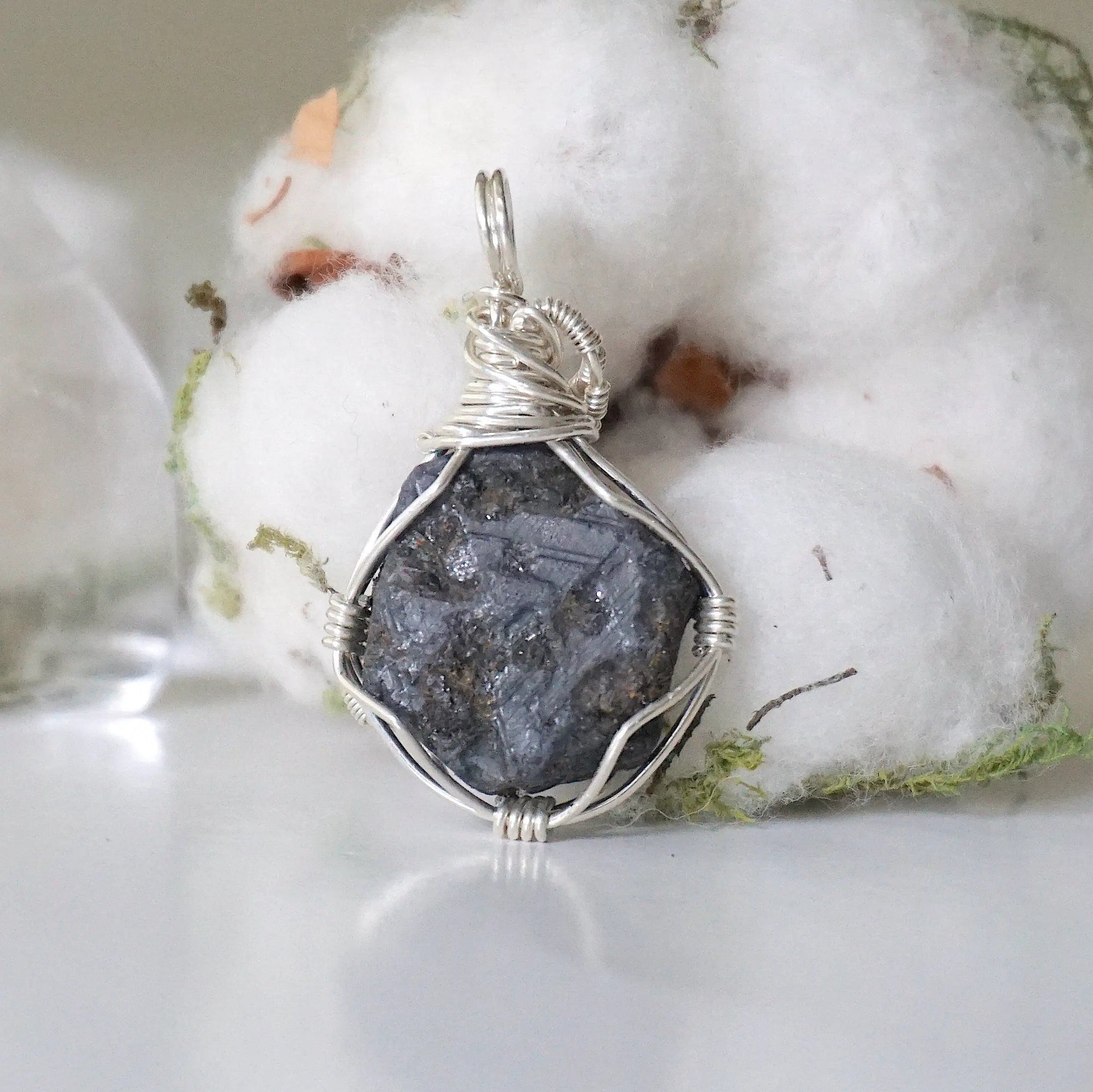 Back view of women's raw sapphire pendant showing the detail of 925 sterling silver wire-wrapping — one-of-a-kind handcrafted crystal jewelry
