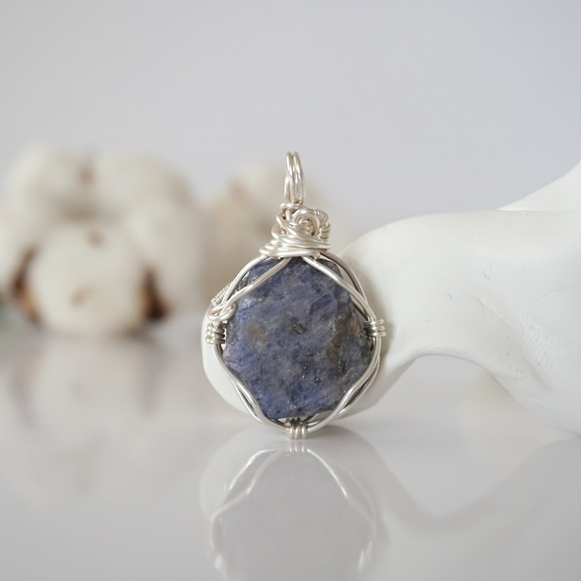 Back view of raw sapphire wire wrapped pendant — silver finish hand-wrapped setting shows craftsmanship and secure stone hold, handmade in Toronto Canada