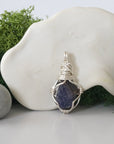 Detailed front angle view of simple raw sapphire pendant in silver wire