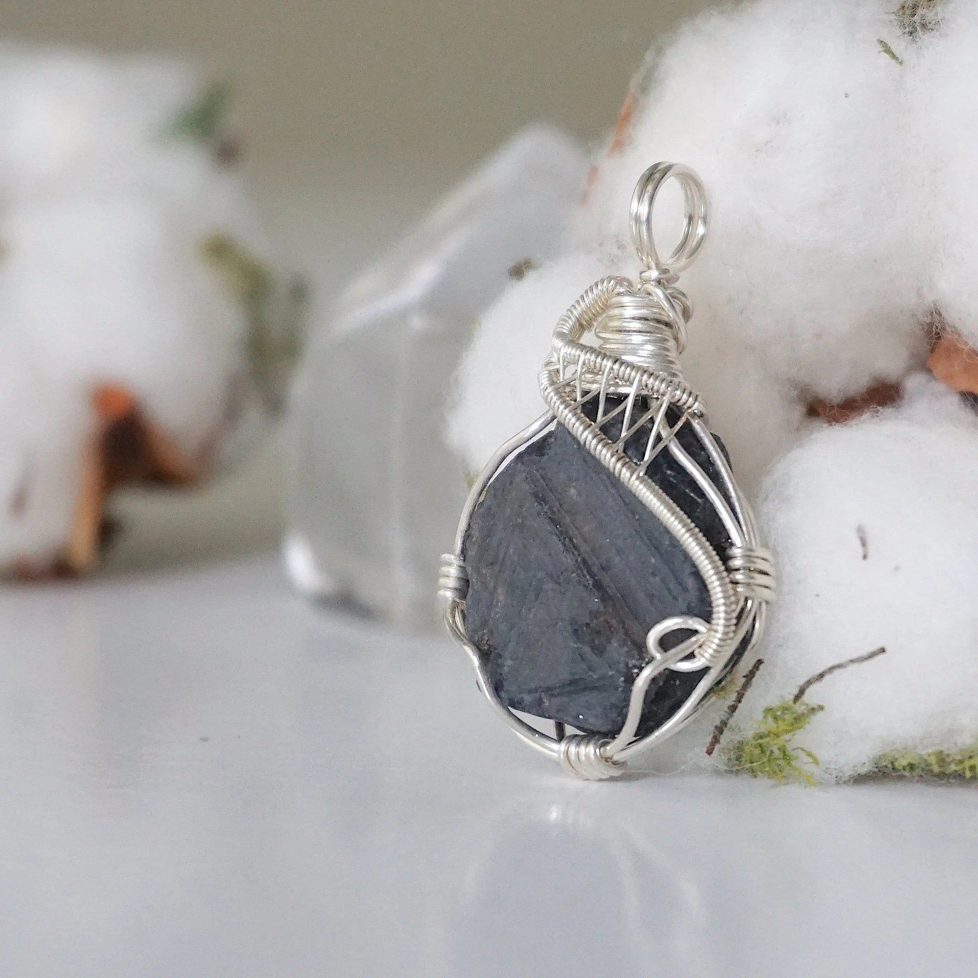 Left-angle close-up of raw sapphire pendant revealing the precision of 925 sterling silver wire-wrapping craftsmanship — women's artisan crystal jewelry