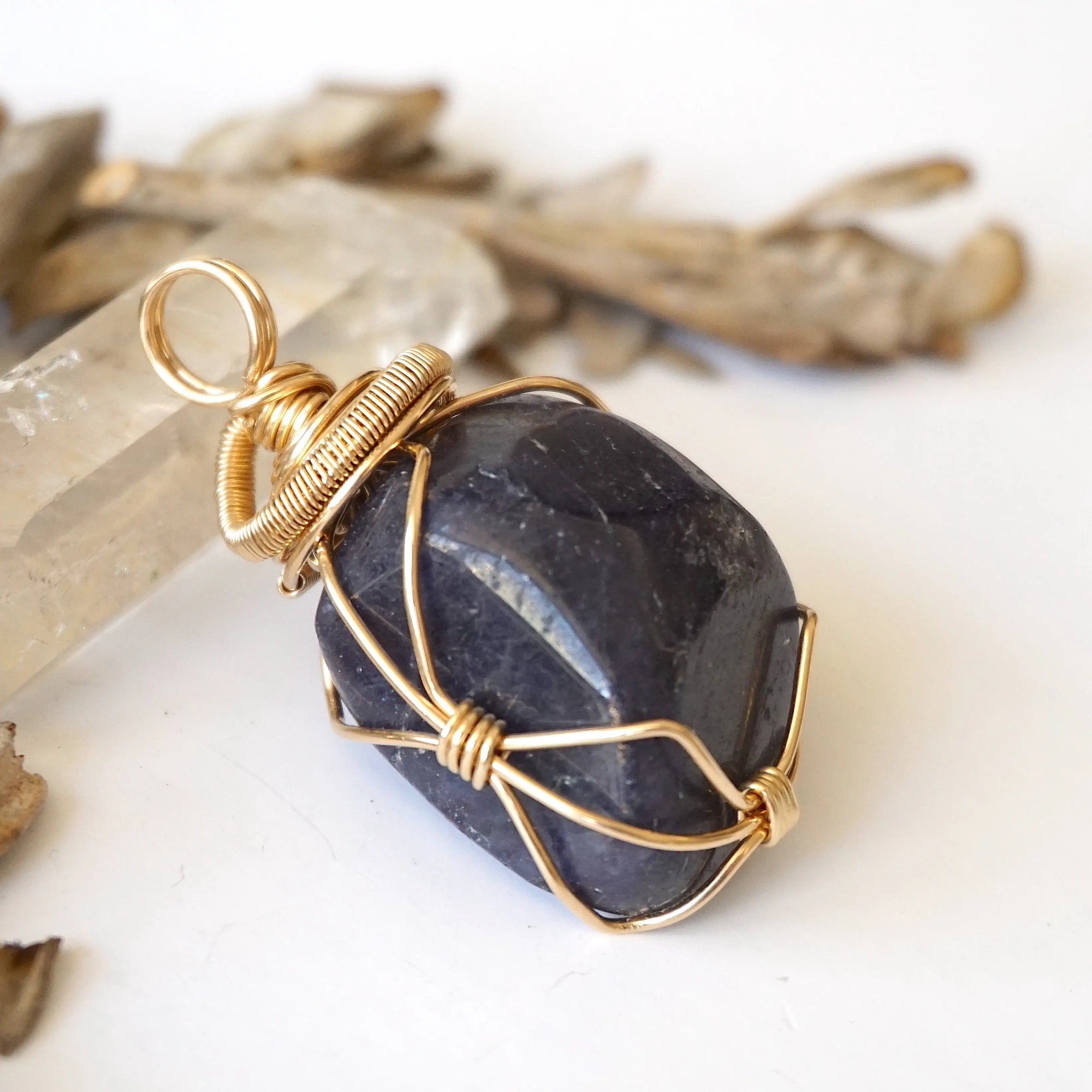 Right-angle detail of women's raw sapphire pendant showing artisan wire-wrapping in 14k gold-filled — handcrafted crystal necklace by Designs by Nature Gems
