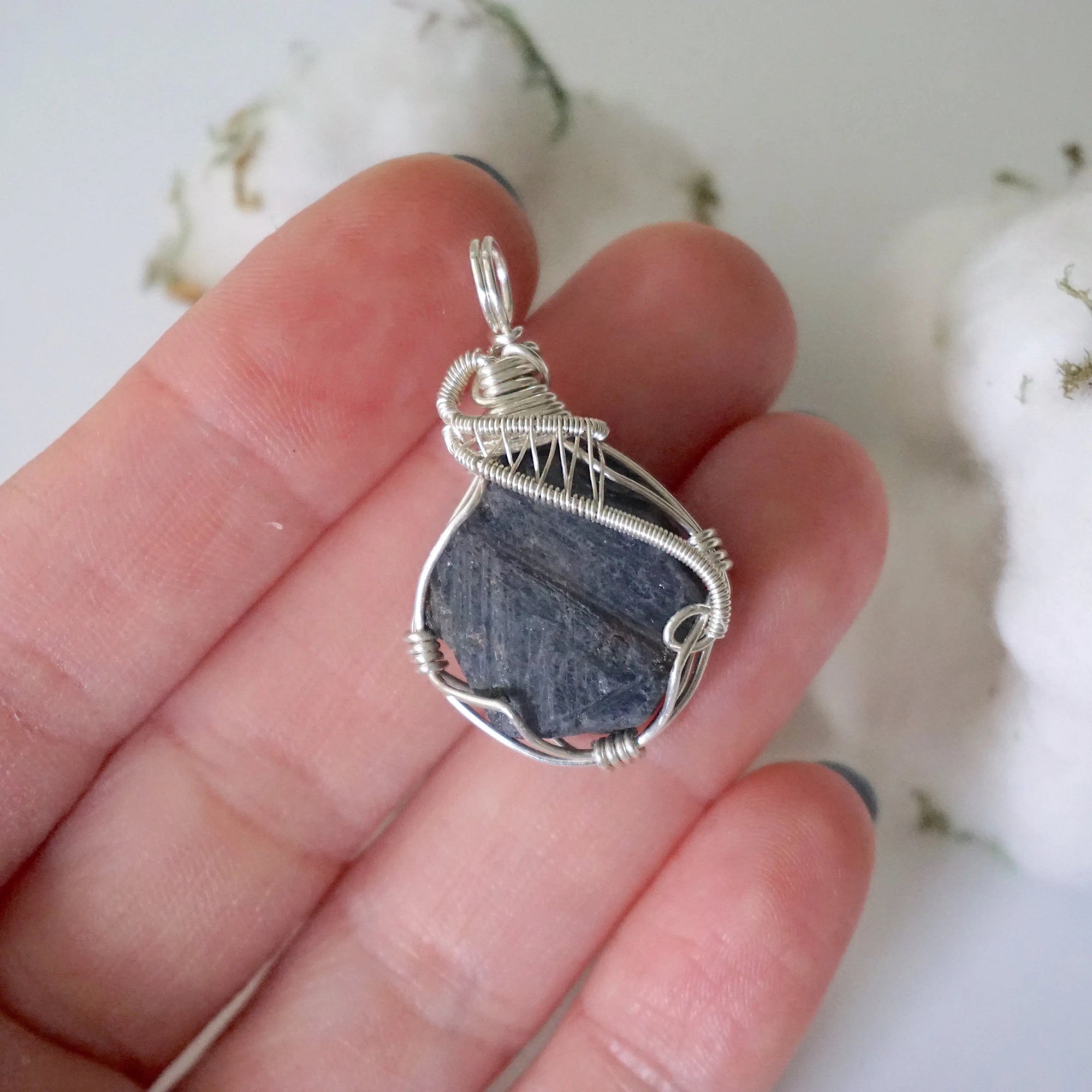 Raw sapphire pendant held in hand to show size — 925 sterling silver wire wrap, women's handcrafted crystal necklace by Designs by Nature Gems