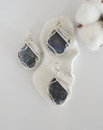Three raw sapphire pendants showing natural variation in stone size, shape, and blue-grey tone — each one of a kind, September birthstone, silver wire wrapped, Designs by Nature Gems