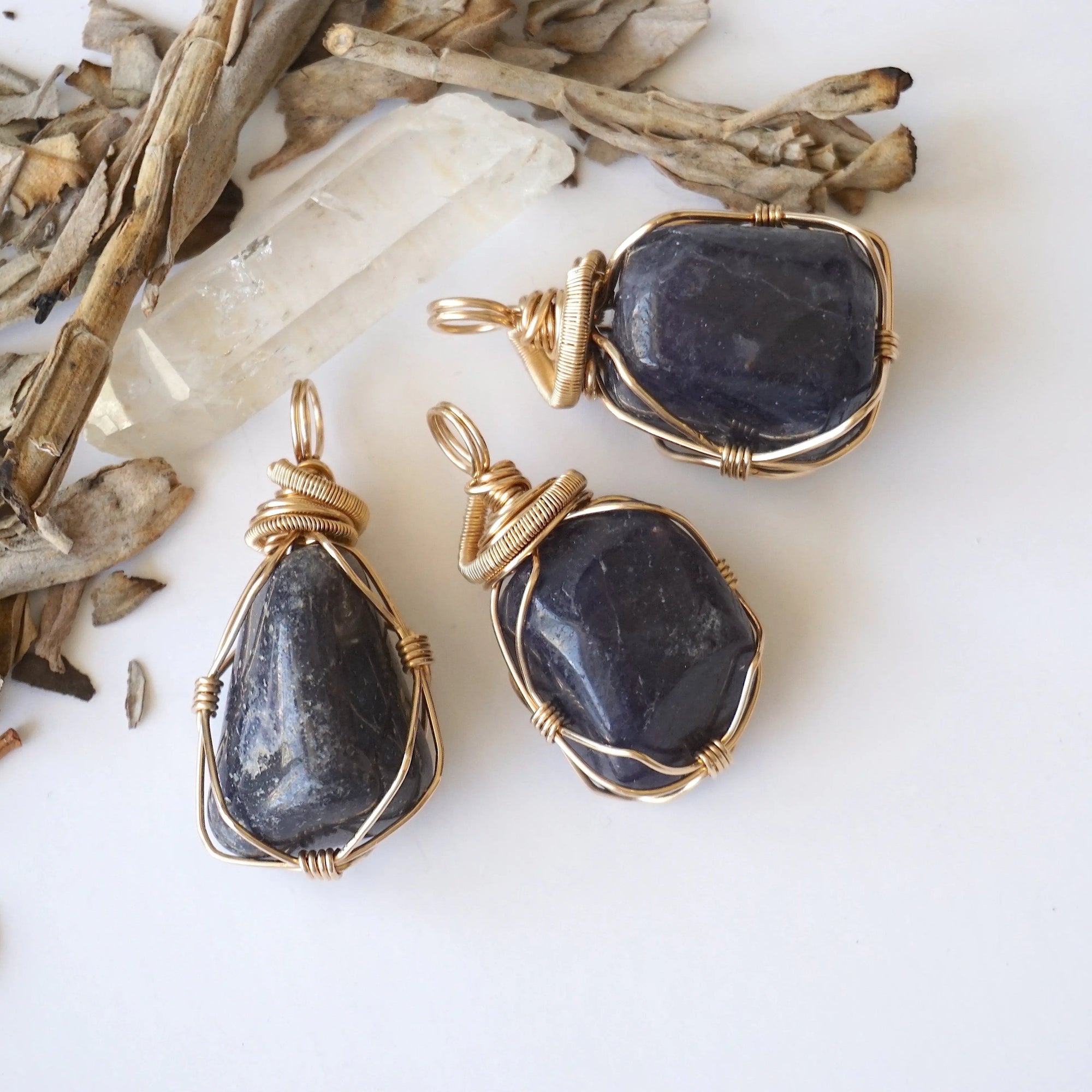 Three raw sapphire pendants showing natural variation in size, shape, and depth of colour — each women's 14k gold-filled wire-wrapped necklace is individually handcrafted and one of a kind