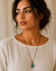 Model wearing raw turquoise necklace with bronze gold wire wrap on antique bronze chain.