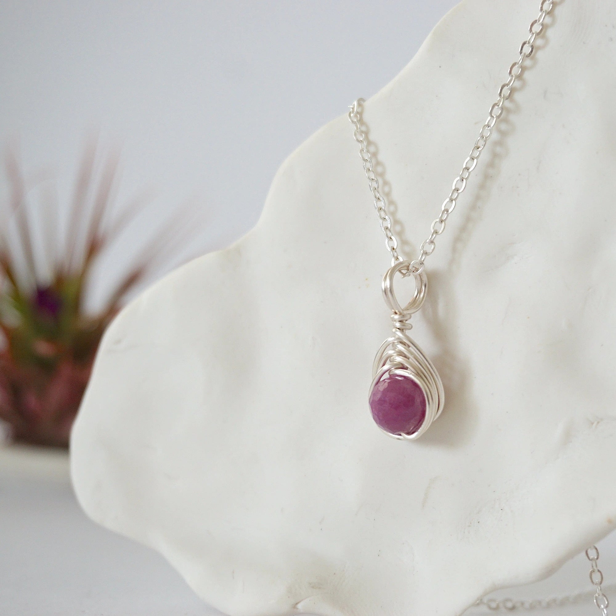 Left side view of silver wire wrapped faceted ruby bead pendant highlighting artisan wire work — minimalist handmade crystal necklace for women