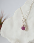 Left side view of silver wire wrapped faceted ruby bead pendant highlighting artisan wire work — minimalist handmade crystal necklace for women