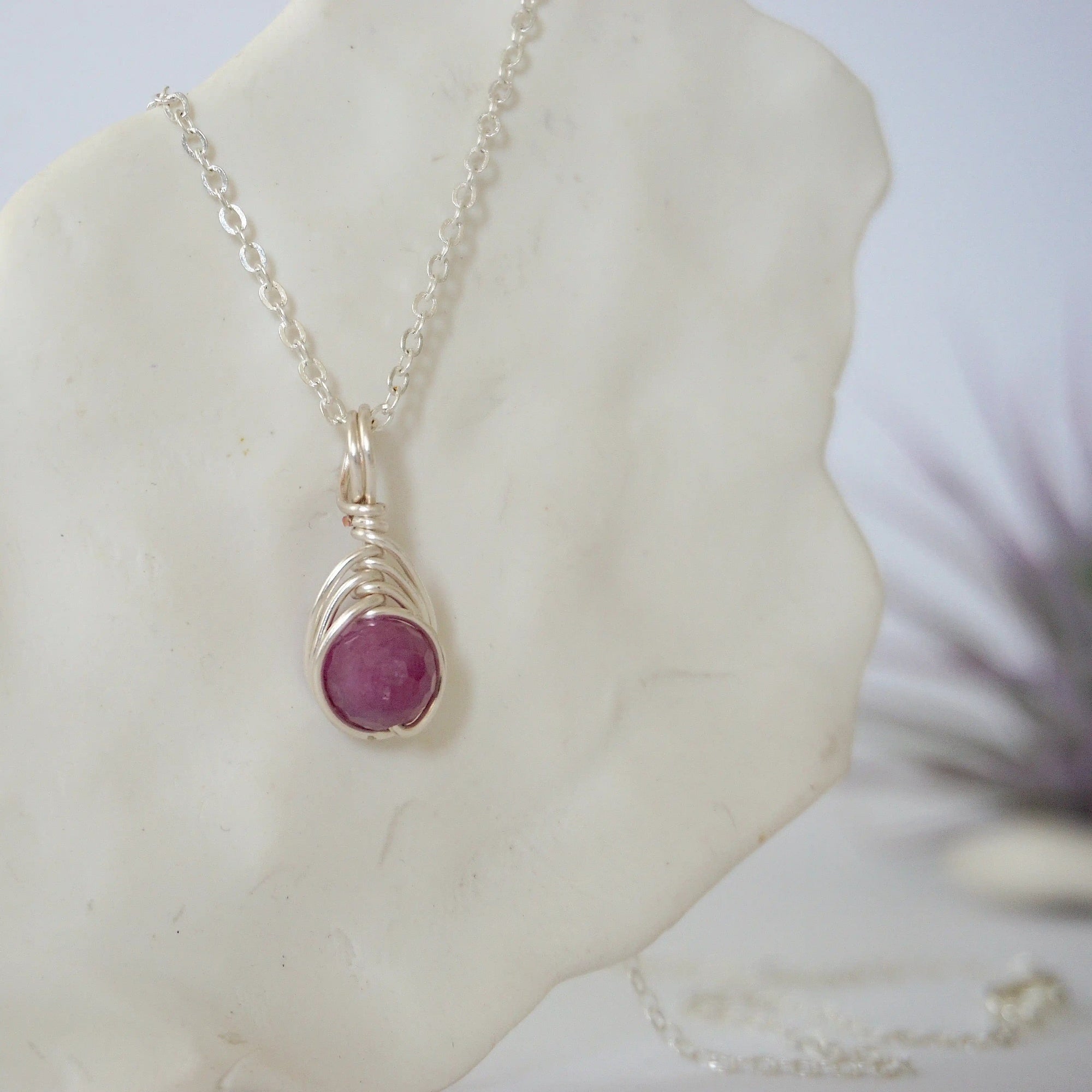 Right side view of minimalist faceted ruby bead pendant showing delicate silver wire wrapping detail — natural July birthstone necklace for women