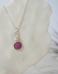 Right side view of minimalist faceted ruby bead pendant showing delicate silver wire wrapping detail — natural July birthstone necklace for women