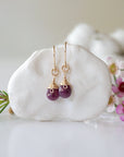 Detailed front view of ruby drop earrings, genuine faceted ruby with minimalist 14k gold filled wire wrapping, Designs by Nature Gems
