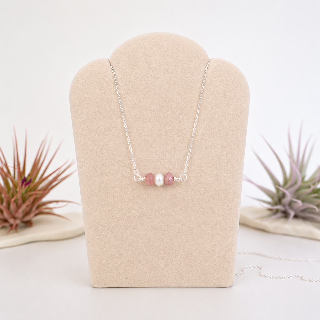 Ruby and freshwater pearl bar necklace in 925 sterling silver on jewelry display, front view