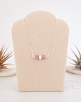 Ruby and freshwater pearl bar necklace in 925 sterling silver on jewelry display, front view