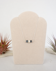 Sapphire and freshwater pearl bar necklace in 925 sterling silver on jewelry display, front view