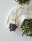 Sapphire and freshwater pearl pendant on gold plated brass chain laying flat, handmade wire wrapped jewelry for women