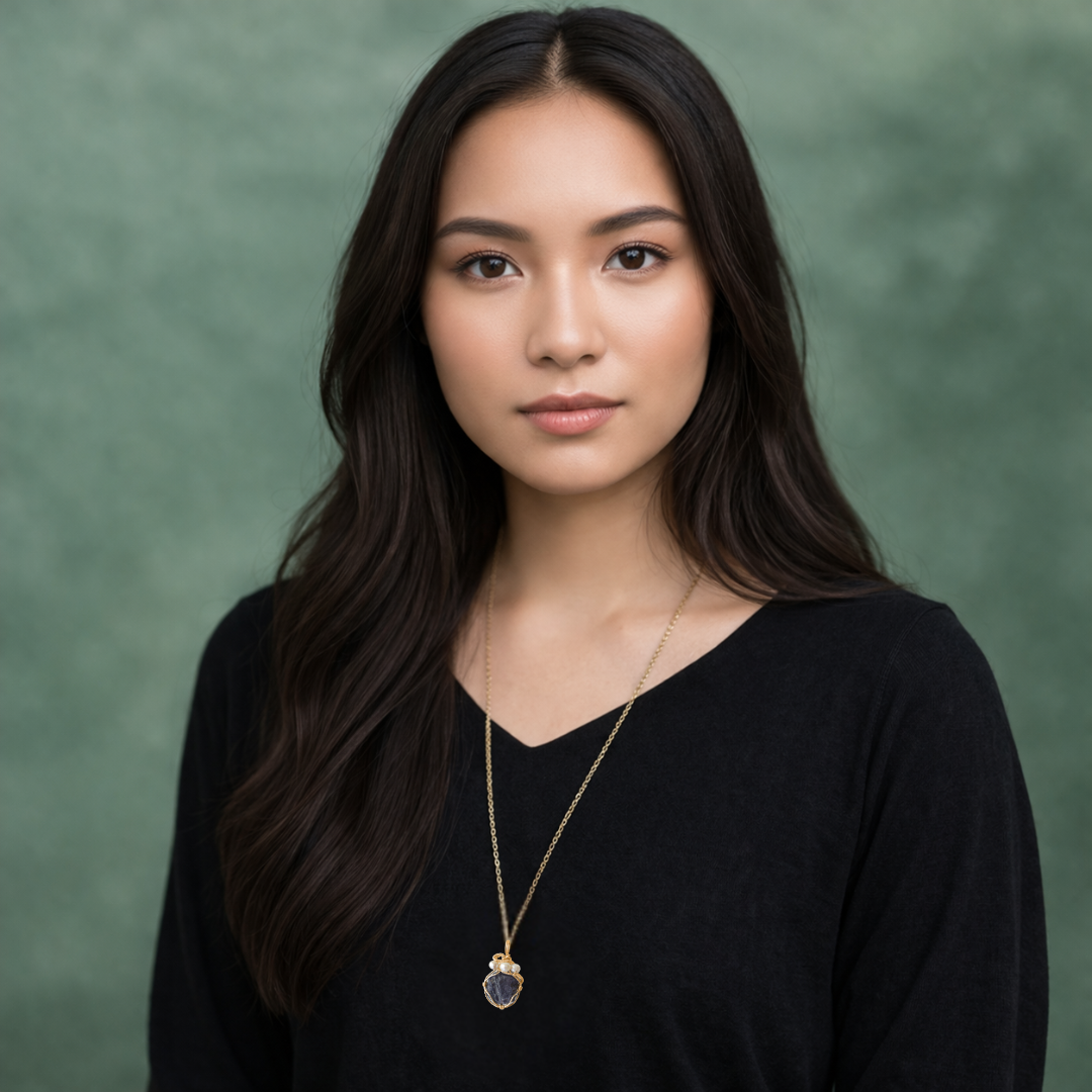 Model wearing sapphire and freshwater pearl pendant on gold plated brass chain.