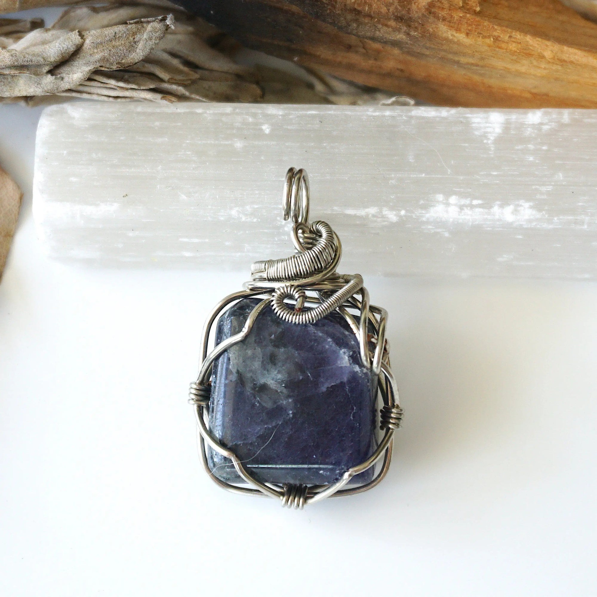 Back view of natural sapphire pendant showing the detail of dark silver wire-wrapping — one-of-a-kind handcrafted crystal jewelry