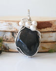 Detailed front view of silver wire wrapped shungite and freshwater pearl pendant, unique artisan necklace