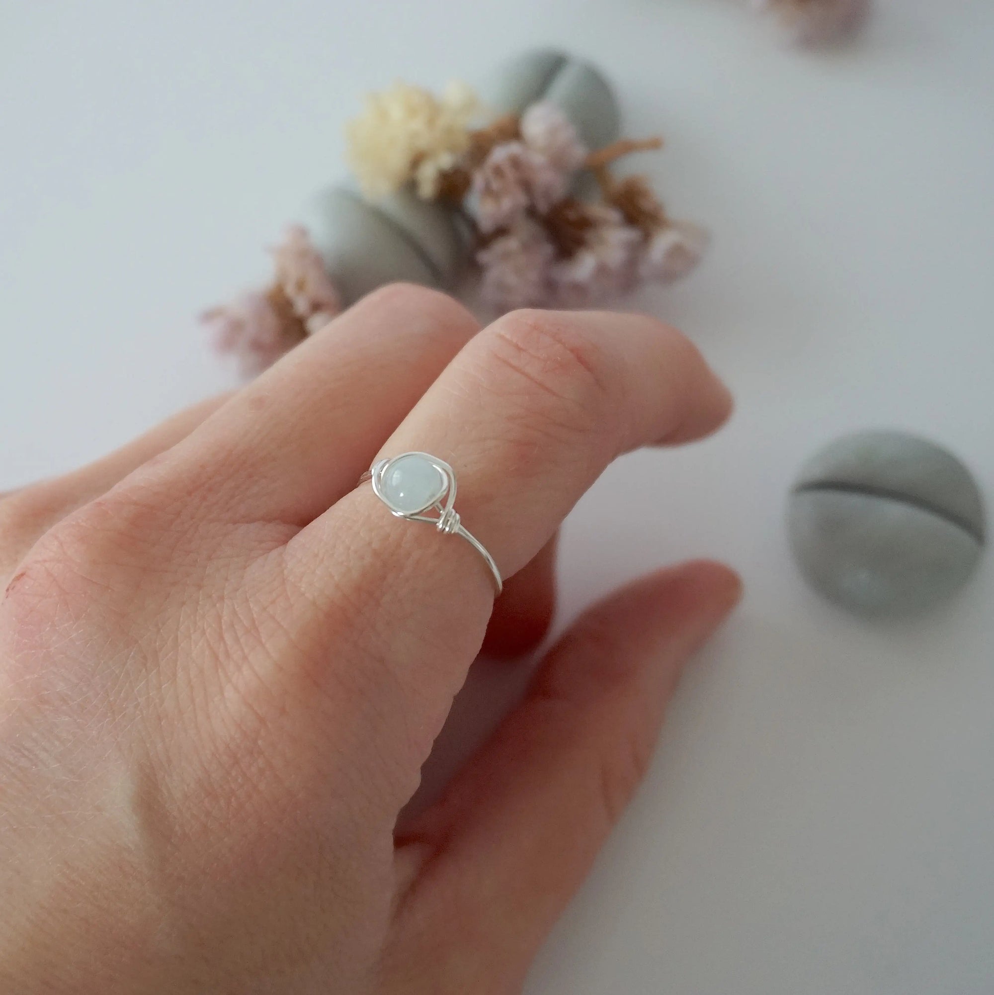 Minimalist silver aquamarine ring on female model's hand, handcrafted, Designs by Nature Gems