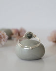 Back view of minimalist silver emerald ring highlighting handcrafted wire wrapping detail.