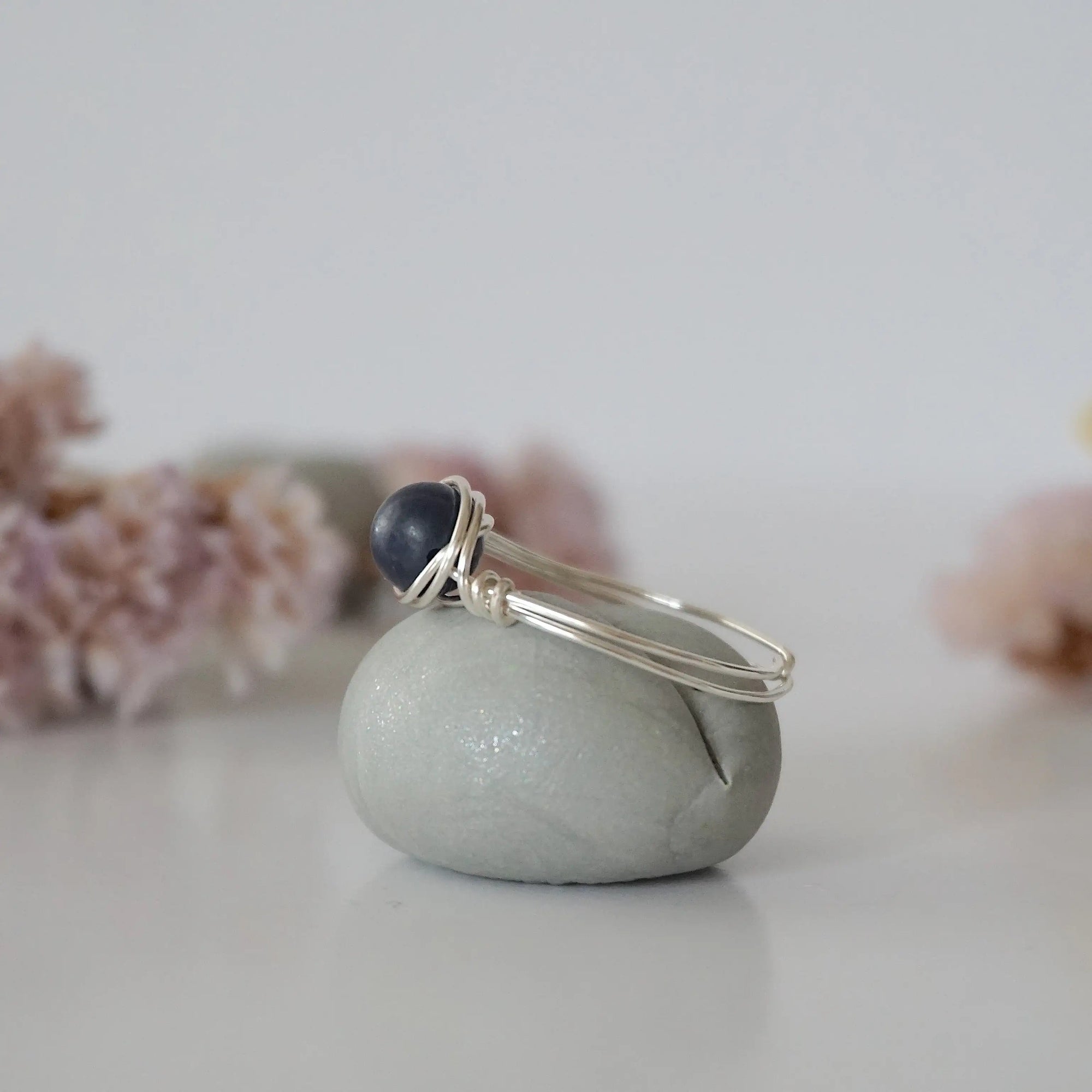 Side-angle detail of silver sapphire ring showing the minimalist wire-wrapped setting and natural 6mm sapphire bead