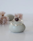 Back view of minimalist silver wire wrapped garnet ring band, dainty January birthstone jewelry