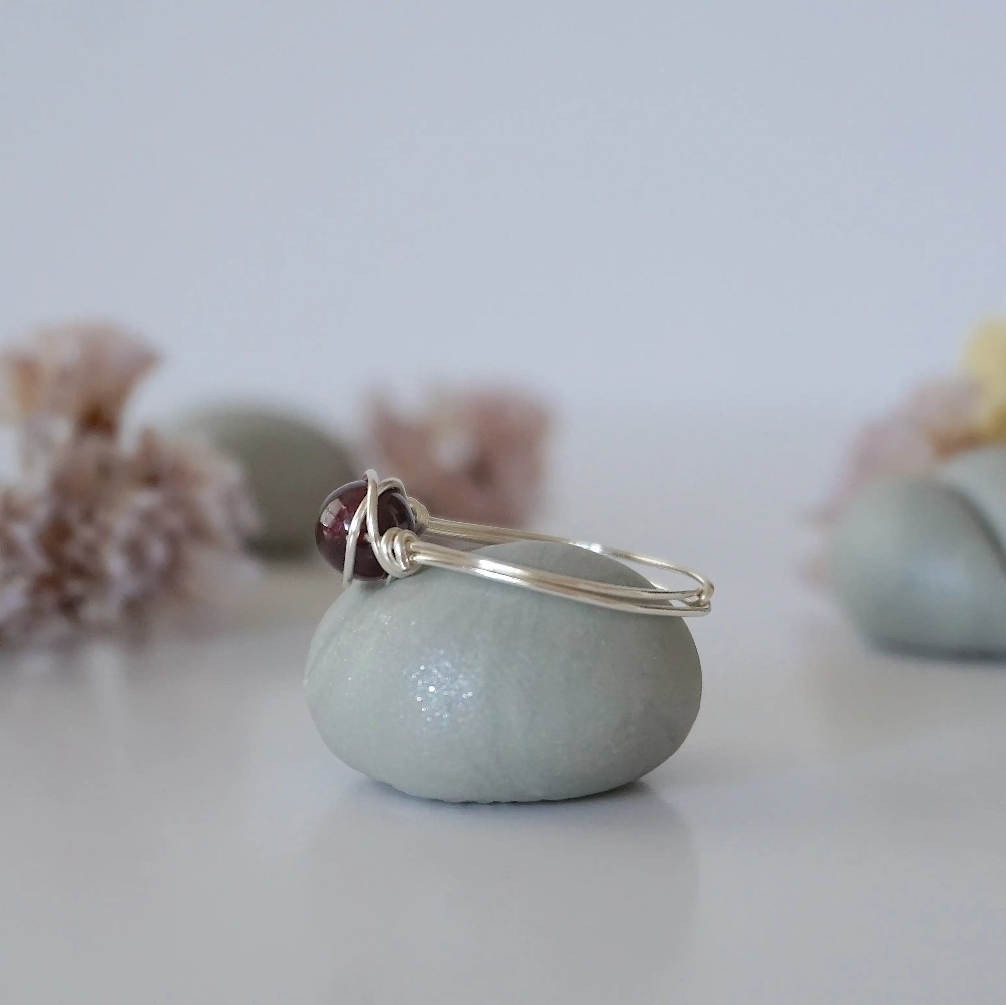 Side angle of simple garnet bead ring with minimalist silver wire wrap, delicate everyday ring