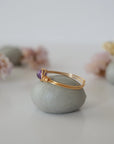 Side view detail of gold amethyst ring, minimalist wire wrap holding polished 6mm natural amethyst bead