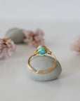 Back view of simple turquoise ring in gold plated copper showing handmade wire wrapping detail and craftsmanship quality