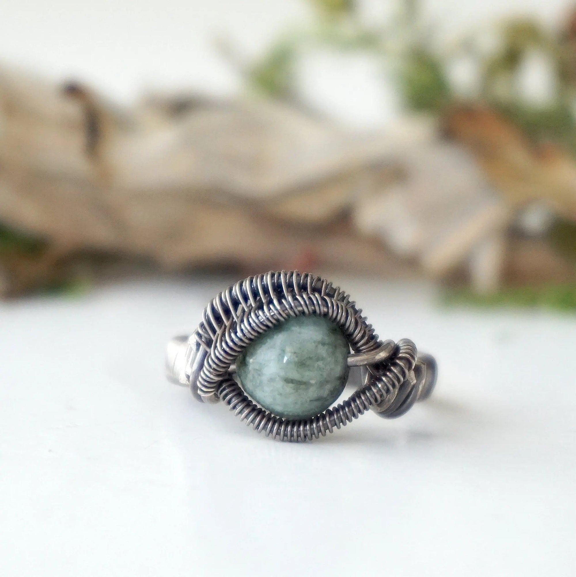 Front view of wire wrapped emerald ring for men in antiqued sterling silver with natural 8 mm emerald bead