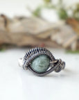 Front view of wire wrapped emerald ring for men in antiqued sterling silver with natural 8 mm emerald bead