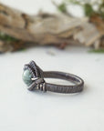 Left side band detail of emerald ring for men in antiqued sterling silver with artisan finish