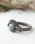 Left side detail of men's emerald ring in antiqued sterling silver with handcrafted wire wrapping artistry