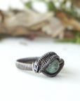 Right side detail of men's emerald ring in antiqued sterling silver showing artisan wire wrapping and emerald bead