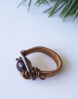 Bird’s-eye view of a wire wrapped garnet ring showing the centered garnet crystal and band width