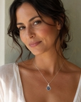Woman wearing a raw sapphire pendant necklace in 925 sterling silver wire wrap — September birthstone jewelry handcrafted in Toronto by Designs by Nature Gems