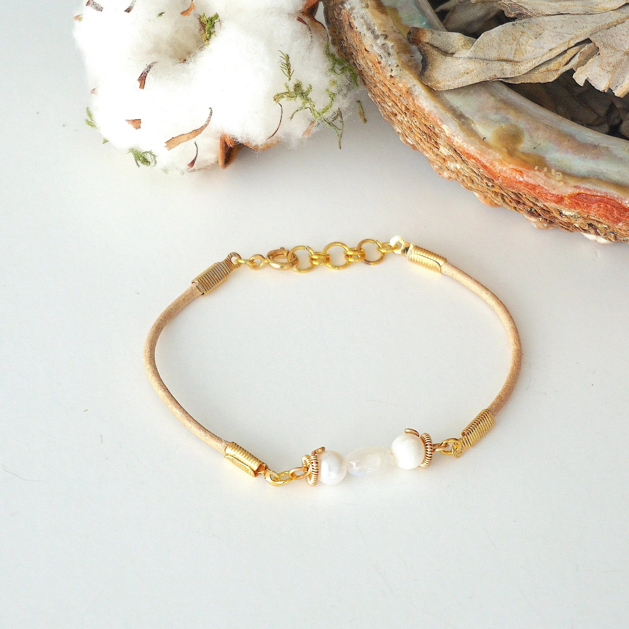 Bird’s-eye view of a women’s pearl and moonstone leather bracelet highlighting gemstone arrangement and leather cord