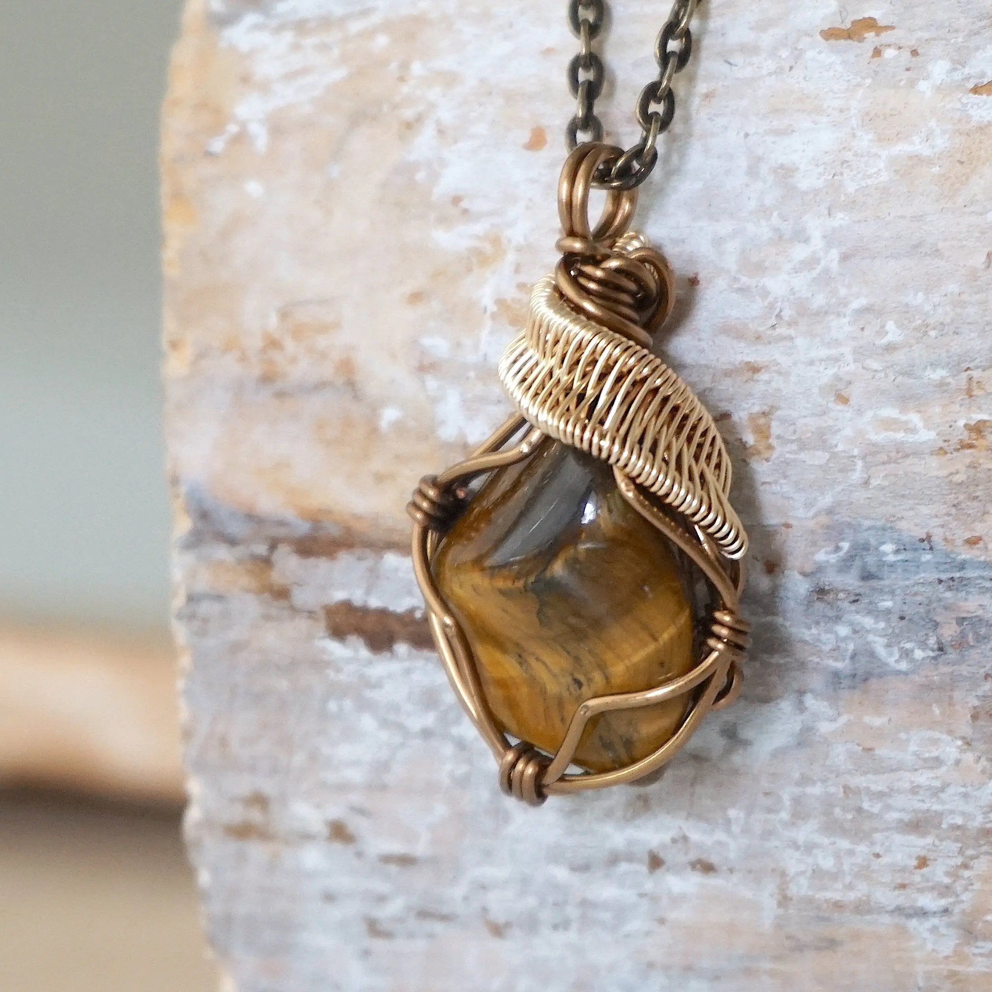 Left side view of yellow tiger's eye pendant showing bronze and gold wire wrapping — handmade crystal necklace for all genders